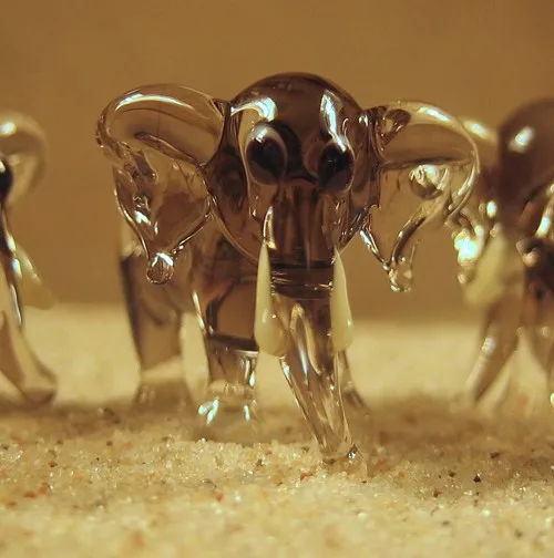 Skleněná figurka stojícího světle šedého slona