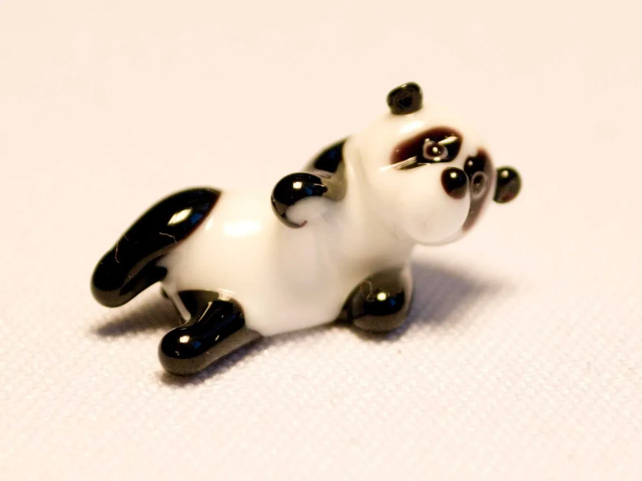 Skleněná figurka ležící pandy