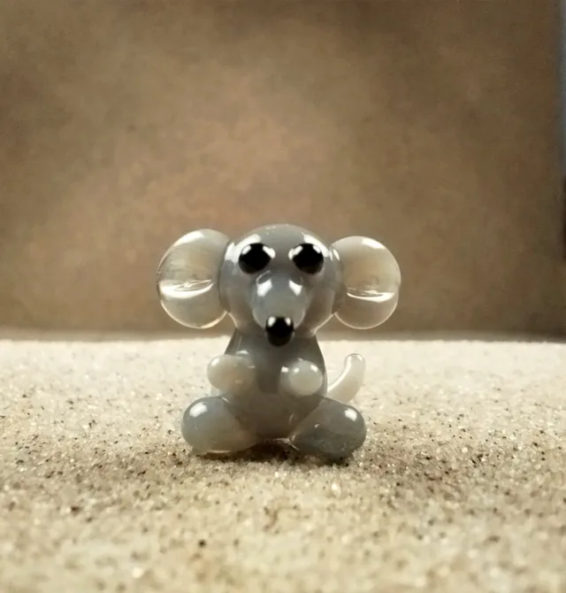 Skleněná figurka sedící šedé myši
