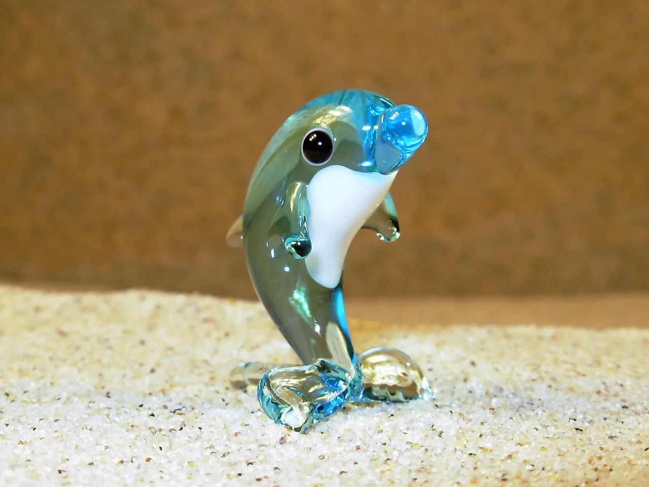 Skleněná figurka stojícího světle modrého delfína