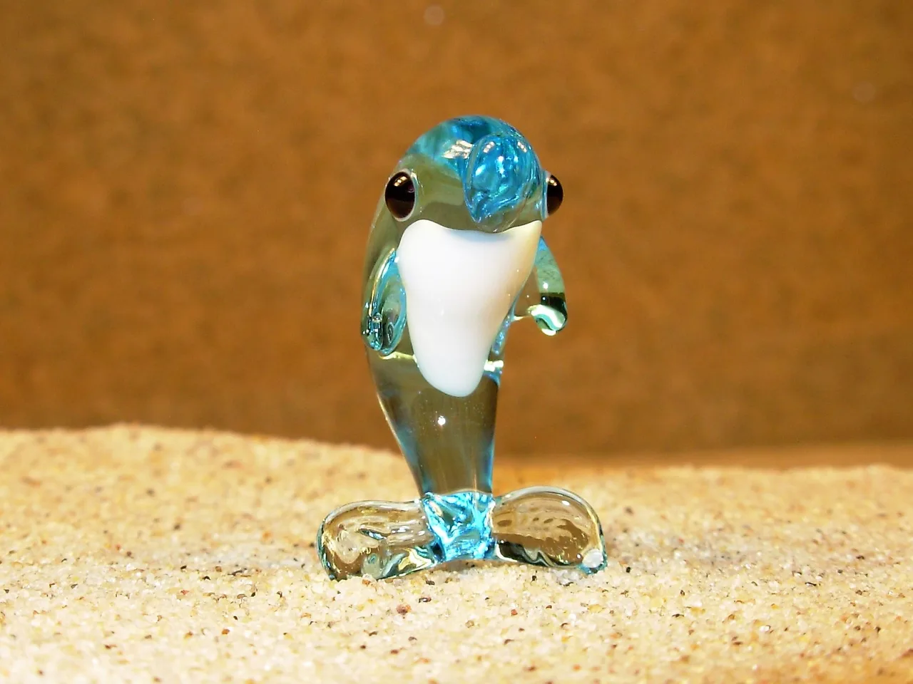 Skleněná figurka stojícího světle modrého delfína