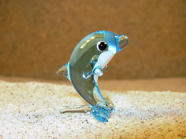 Skleněná figurka stojícího světle modrého delfína